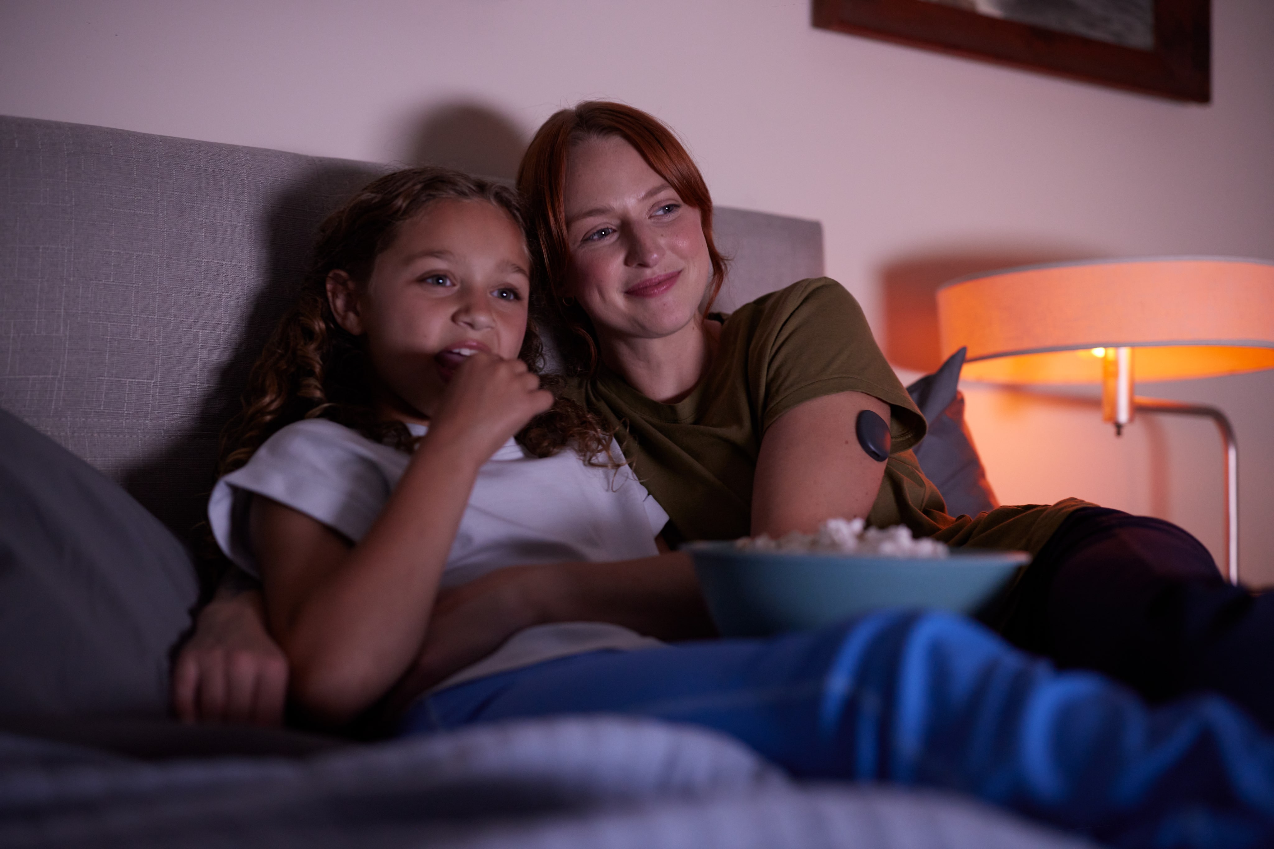 Eversense glucose CGM user smiling, standing outside in a forest, wearing her device on arm